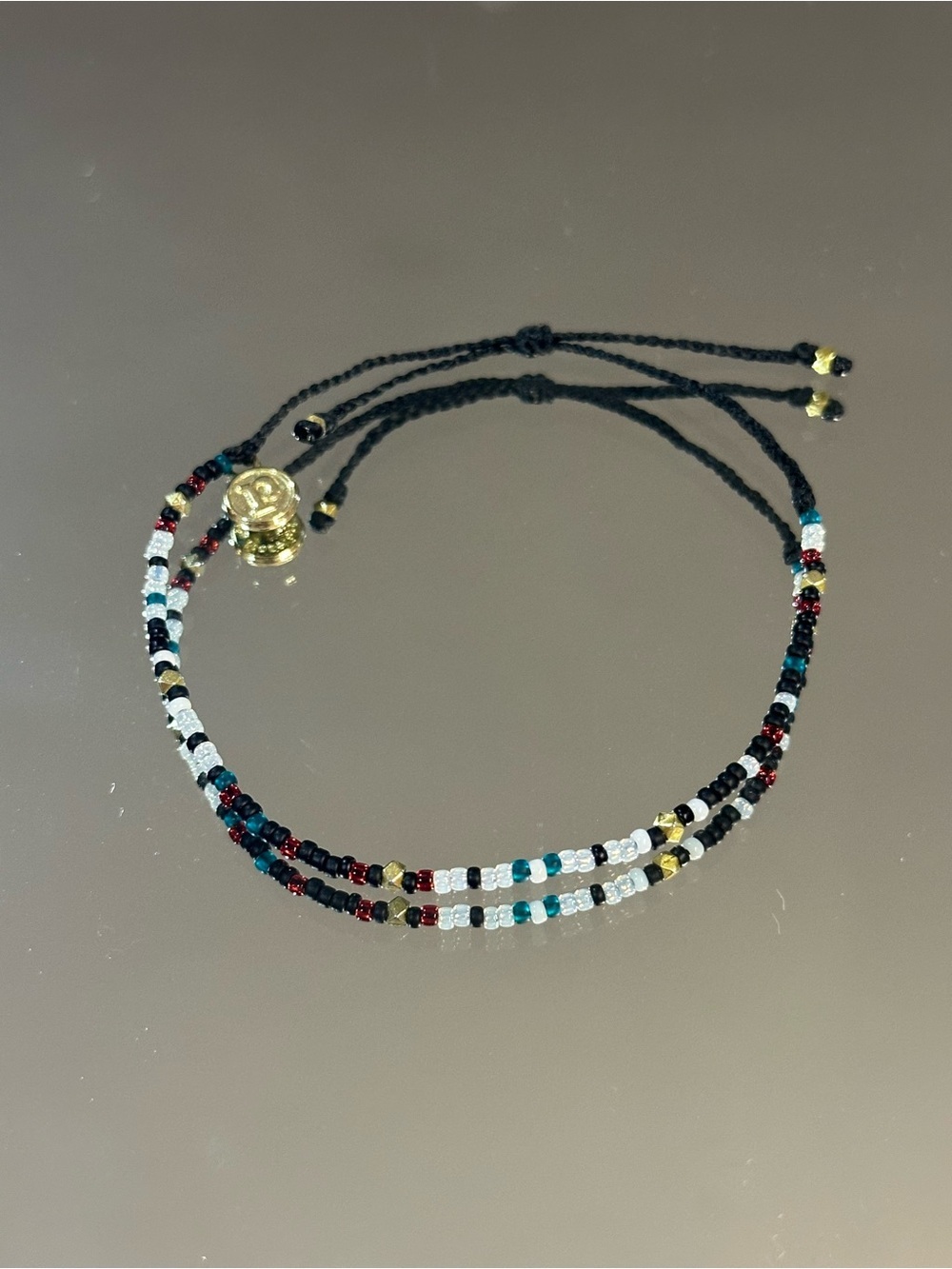 Pura Vida. Black Cord Bracelet with Red, Teal, White & Gold Beads